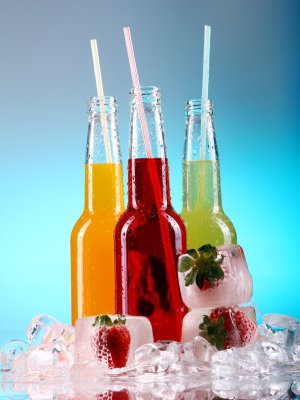 Bottles with colorful cocktails over blue background