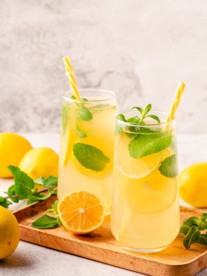 Lemonade with lemon, mint and ice cubes in glass, selective focus